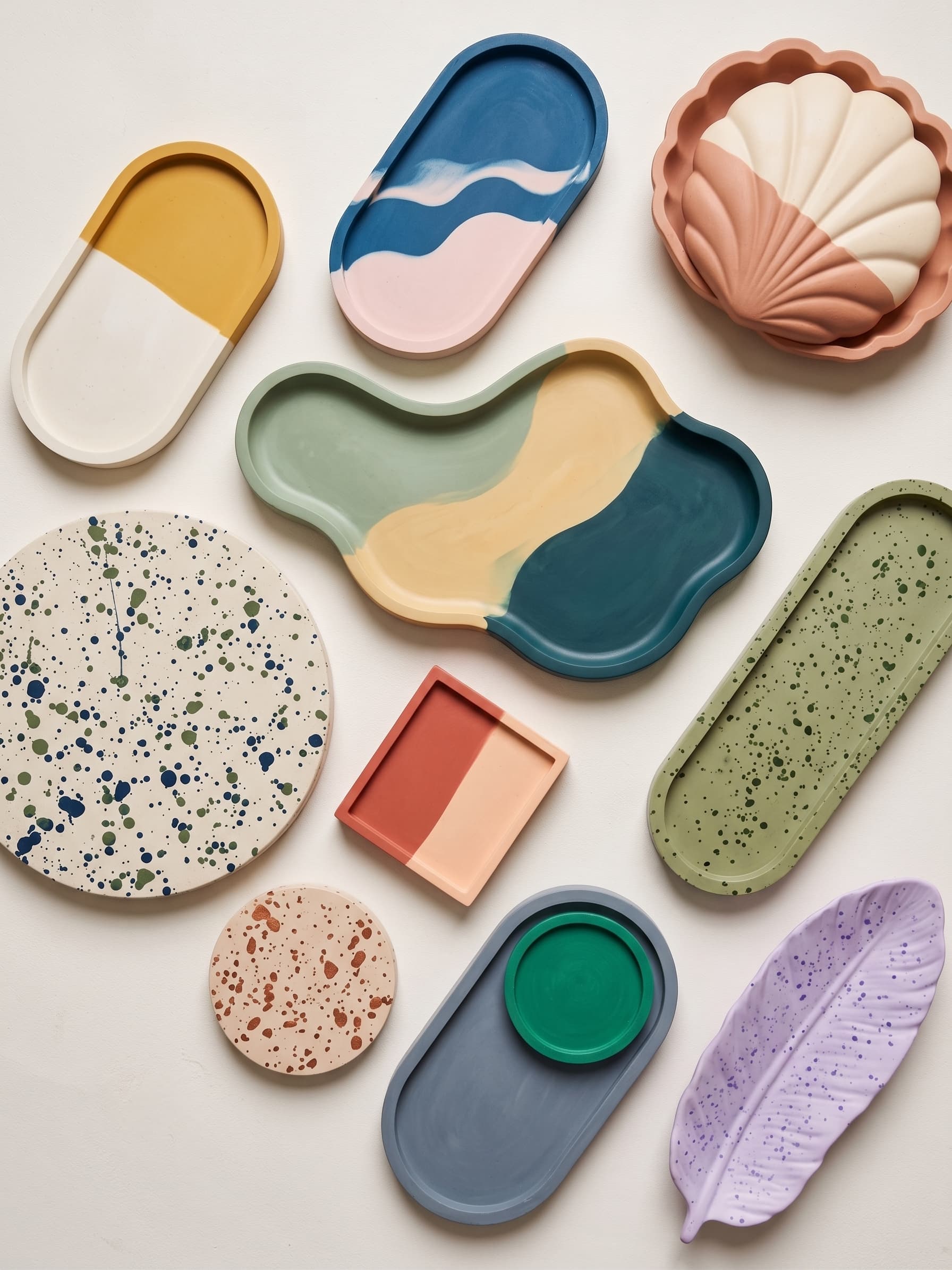 Bandejas de yeso cerámico de distintas formas —concha, hoja, nube, ovaladas y redondas— pintadas en colores